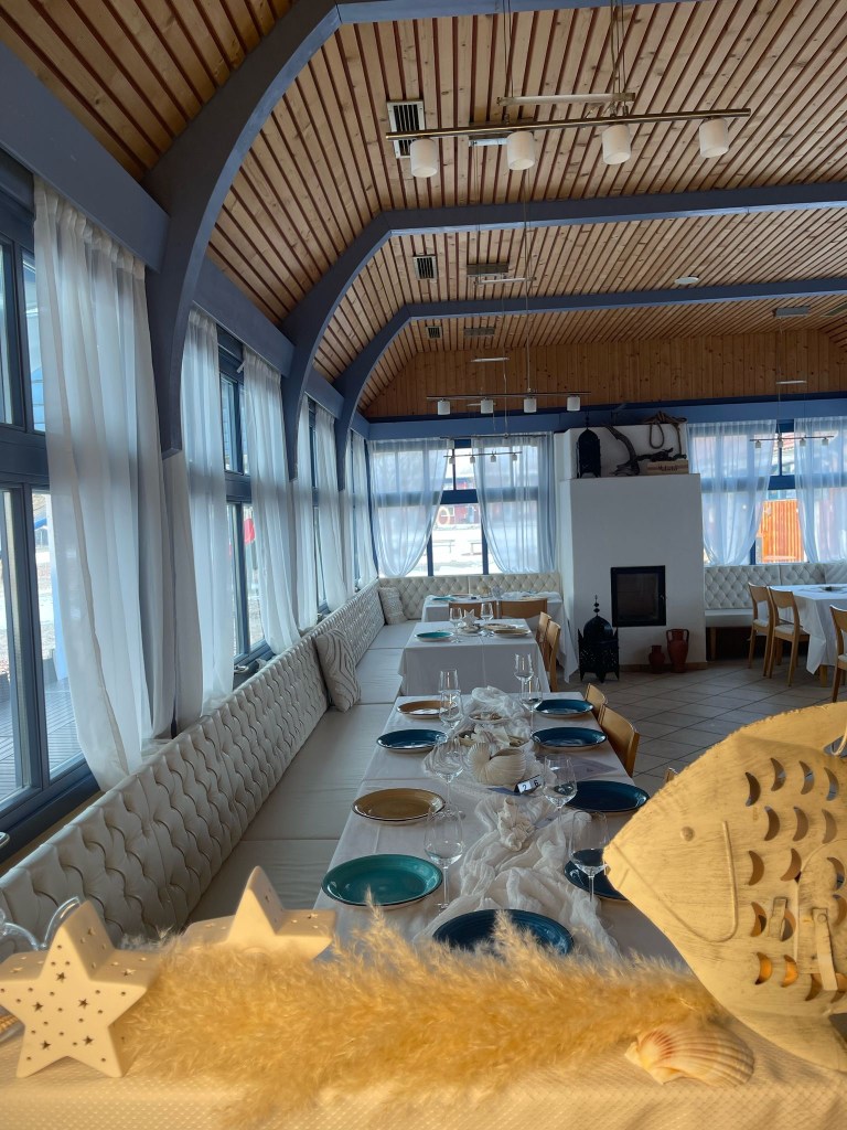 Abstruse Restaurant Raum mit traditionellen dezenten Tischen, gemütlichen und bequemen Sitzmöbeln, großen Fenstern, grosse...